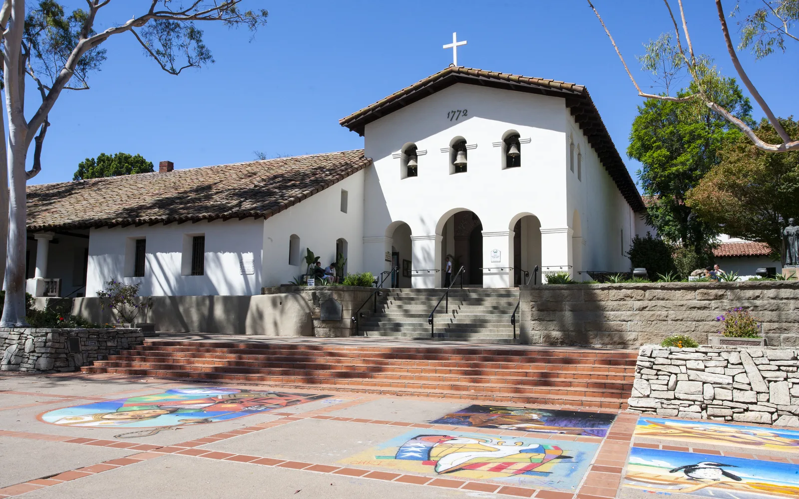 Exterior view of Mission San Luis Obispo de Tolosa with white adobe walls, red tile roof, and bell tower